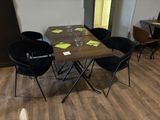 une table en bois avec quatre chaises et un verre de vin posé dessus