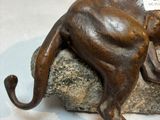 a statue of a cat that is sitting on a rock