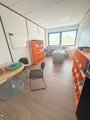 une pièce avec une table, des chaises et des étagères