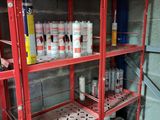 many cans of paint on the shelves in the garage