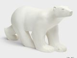 une petite figurine d'ours polaire blanc sur fond blanc