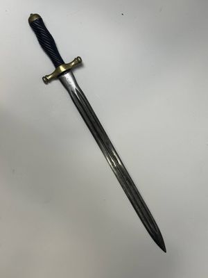 a sword with a black handle on a white surface