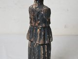 wooden figurine of a woman in a black dress and hat