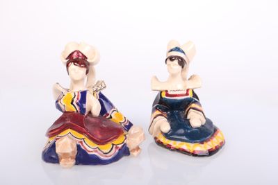pair of ceramic figurines of a woman and a man sitting on a bench
