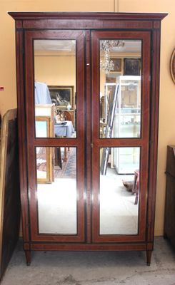 une grande armoire en bois avec deux miroirs sur les portes