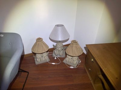 three lamps that are sitting on the floor next to a chair