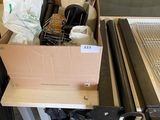 une boîte contenant divers objets, posée par terre à côté d'une table