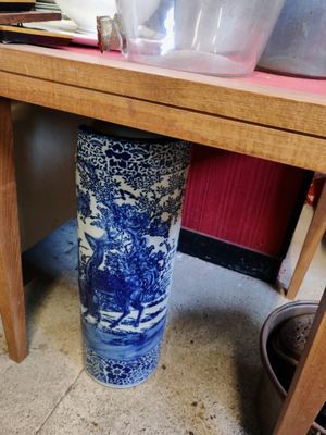 un vase bleu et blanc posé sous une table en bois