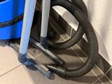 a blue vacuum sitting on the floor next to a blue bucket