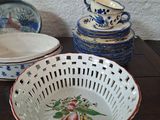 many bowls and cups on a table with a wall in the background