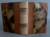 un vieux livre à la couverture marron posé sur une table