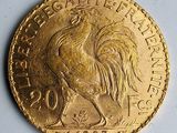 une image représentant une pièce d'or sur laquelle figure un coq couché sur le côté