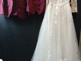 une robe de mariée suspendue à un portant dans une pièce
