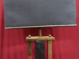 un petit téléviseur posé sur un meuble surmonté d'un tableau noir