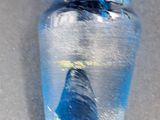 a glass bottle with a blue liquid inside of it