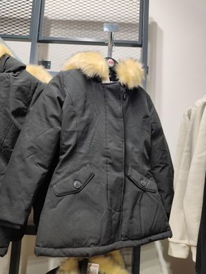 deux manteaux suspendus à un portant dans un magasin de vêtements