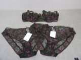 three pieces of underwear are on a bed with tags attached to them