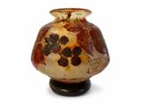un vase posé sur un support sur une surface blanche