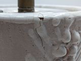 a close up of a white bowl with a metal handle