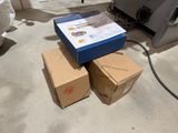 two boxes sitting on the floor next to a printer