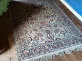 un tapis posé à même le sol dans une chambre où se trouve un lit