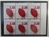 four stamps with red leaves on them on a white surface