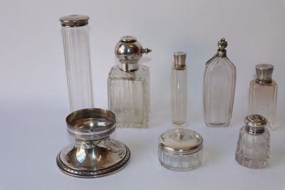 de nombreux objets en argent et en verre posés sur une surface blanche