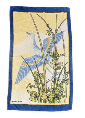 the blue bird is flying over the flowers on the yellow towel