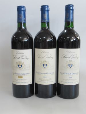 trois bouteilles de vin posées sur une table blanche