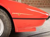 a close up of a red sports car parked in a garage