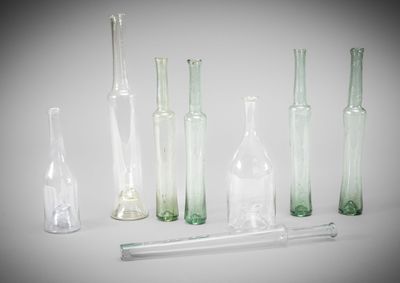 many glass bottles and a pipe in the middle of the picture