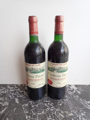 two bottles of red wine sitting on a table