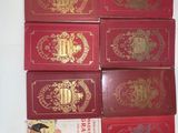 six red books with gold designs are stacked on top of each other