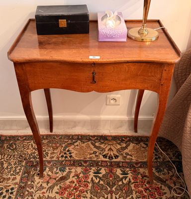 une petite table en bois sur laquelle est posée une lampe