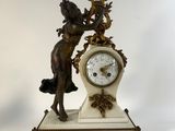 a statue of a woman holding a clock on top of a table