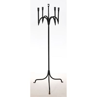 un chandelier en métal noir muni de trois bougies, posé sur un socle