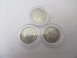 three silver coins sitting on top of each other on top of a table