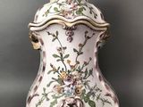 un vase richement décoré, surmonté d'un oiseau