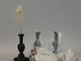 a small black vase with a yellow flower in it