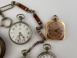 many different types of pocket watches on the table