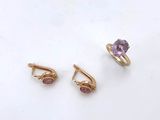 a pair of gold earrings and a ring with a purple stone