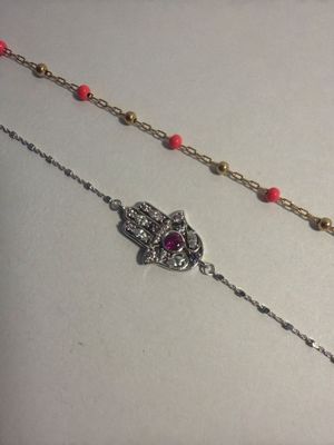 two necklaces that are sitting on top of a table