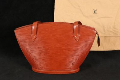 un sac à main Louis Vuitton orange à côté d'un sac beige