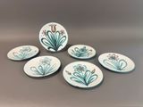 six hand painted plates with flowers on them on a table