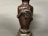a bronze vase with a dragon on it