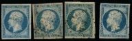 quatre timbres de tailles et de couleurs différentes sur fond noir