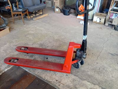 une photo d'un chariot élévateur rouge dans un garage