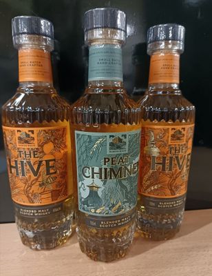 Trois bouteilles de rhum « The Hive » sont posées sur une table