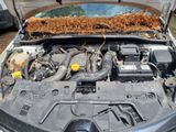the engine of a car with a bunch of dirt on top of it