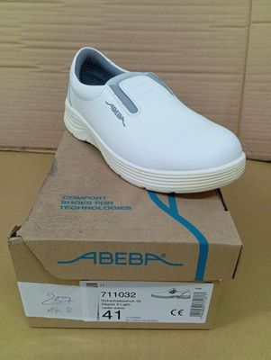 white slip on shoes in a box on top of a cardboard box